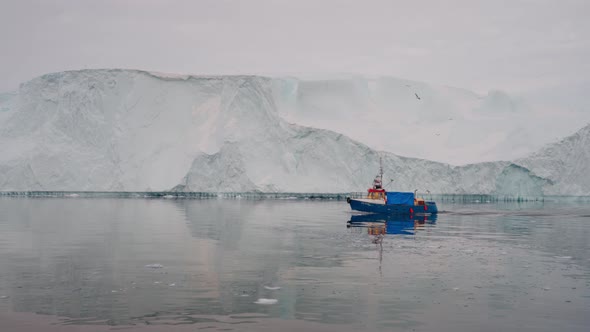 Fishing Trawler On Calm Still Sea By Icebergs