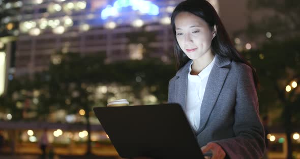 Business woman use of mobile phone in city at night