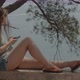Young woman lies on the stone railing and navigates on her smartphone - VideoHive Item for Sale