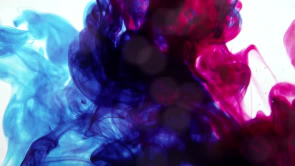 Blue and red ink mixing together in water
