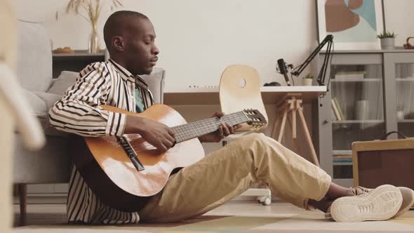 Young African-American Man Playing Guitar and Relaxing