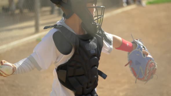 Boy plays catcher in a little league baseball game.