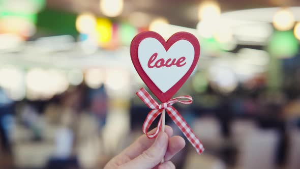 A Stick in the Shape of a Heart on a Blurred Colourful Background