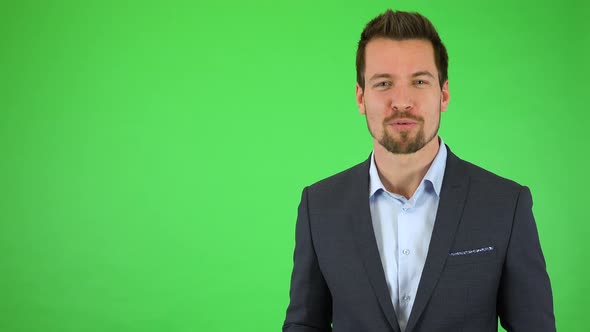 A Young Handsome Businessman Talks Excitedly To the Camera and Points at It - Green Screen Studio