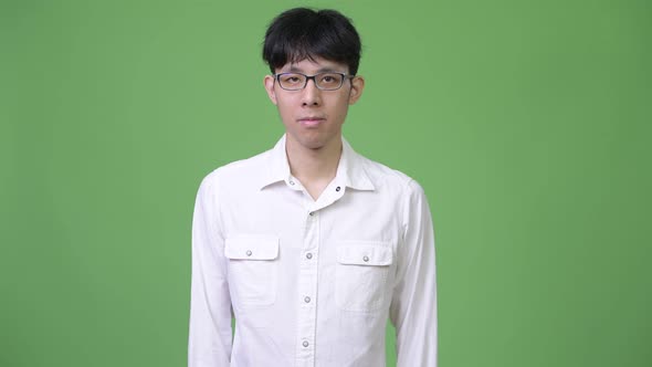 Young Asian Businessman Against Green Background