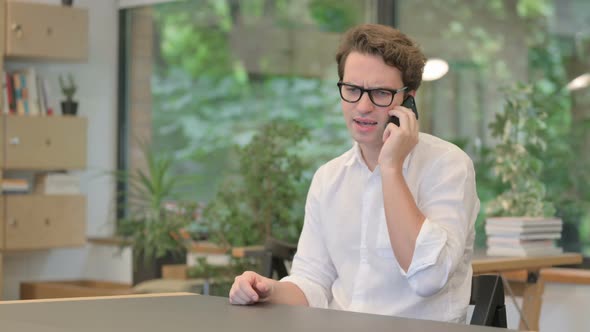 Angry Man Talking on Smartphone in Modern Office