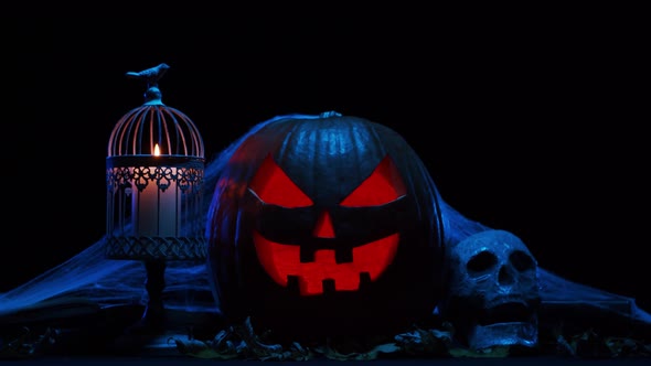 Scary laughing pumpkin and an old skull over the frightening gothic background.