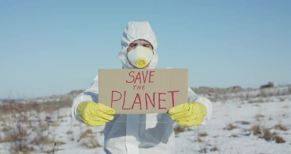 Man Wore in White Full Cover Suit Shows Protest Sign Save the Planet in Winter