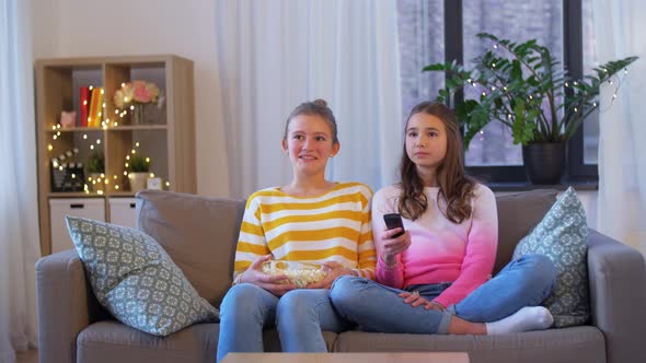 Teenage Girls Eating Popcorn Watching Tv at Home