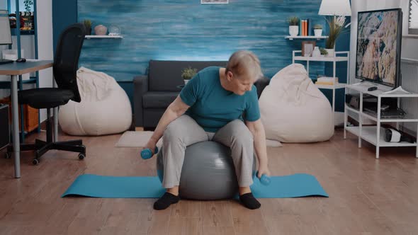 Aged Person Lifting Dumbbells to Practice Fitness Workout