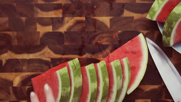 Step by step. Top view. Slicing red watermelon on a wood cutting board.