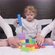 Dad Mom Daughter Plays with Cubes in Nursery on Bed - VideoHive Item for Sale