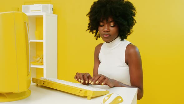 African Woman Is Working at Yellow Retro PC