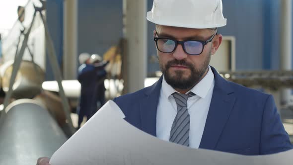  Engineer Studying Blueprint in Industrial Workplace
