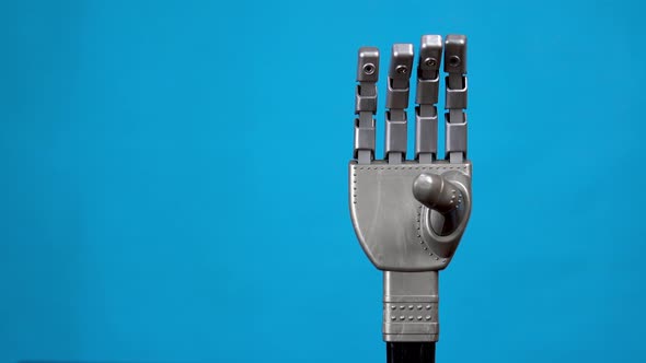 A Mechanical Hand Flexes Its Fingers and Shows a Rock Sign. Gray Cyborg Arm Came To Life and Began