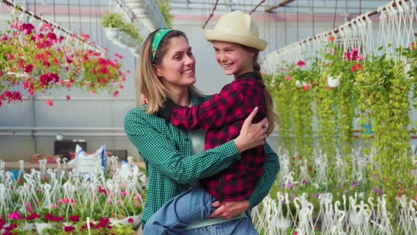 Happy Gardeners Family Kid Girl with Her Mother Mother Holding Her Daughter in Her Arms