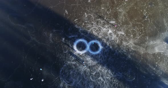 Aerial view of people ice skating on frozen lake