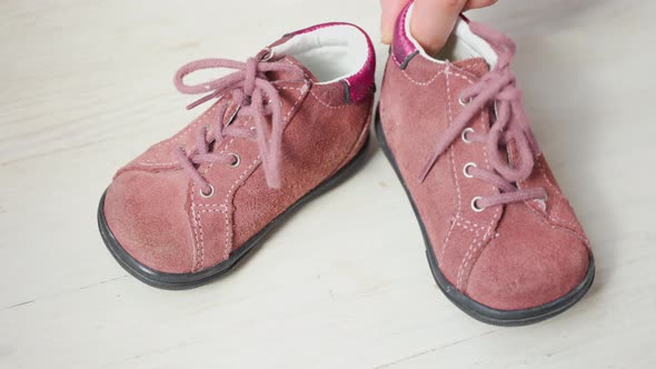 Close Up Children's Crimson Shoes Female Hands Showing Baby Little Girl Shoes