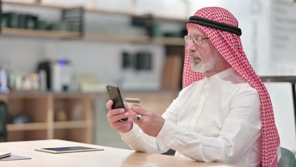 Senior Old Arab Businessman Making Online Payment on Smartphone