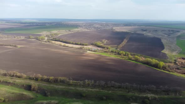 Flying above green and cultivated spring fields