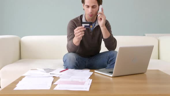 Young man with credit card using laptop