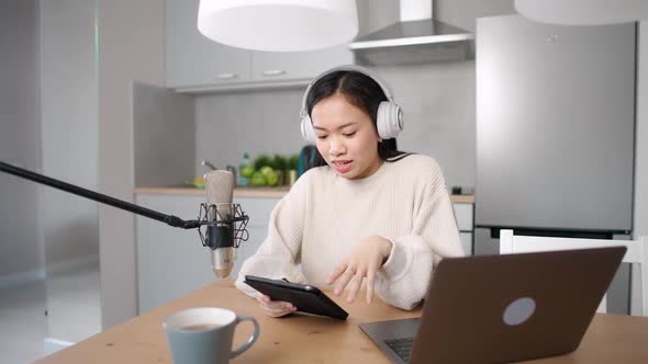 Asian Female Streamer Makes a Live Podcast for Social Networks Remotely Working While Sitting in the