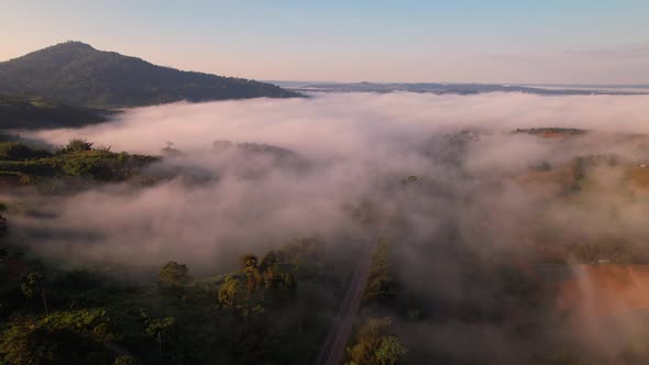 A sea of clouds above the valley and the mountains in the background. 4K Aerial video