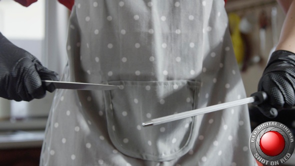 Woman Chef Is Sharpening Knife With A Steel Rod Sharpener In The Kitchen In Slow Motion