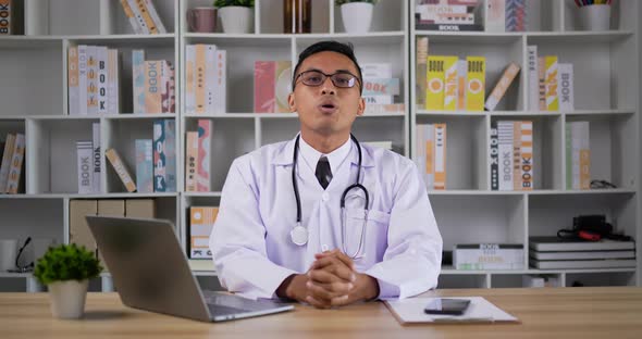 Doctor making conference call and looking at camera