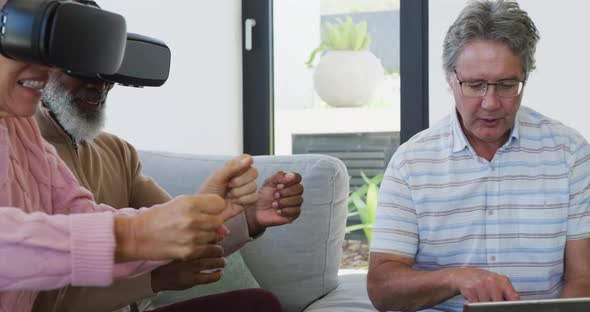 Happy senior diverse people using vr headsets at retirement home