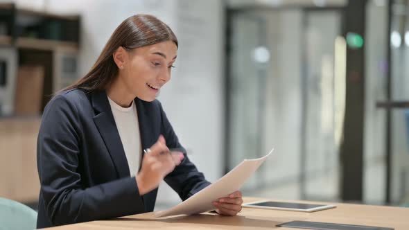 Businesswoman Reading Documents and Celebrating