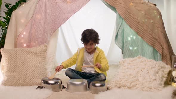 Boy with Pots Playing Music in Kids Tent at Home