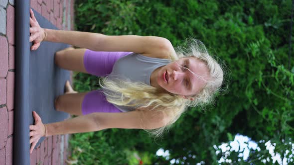 Blonde Woman Trains in the Evening Does Yoga Slow Motion Vertical View