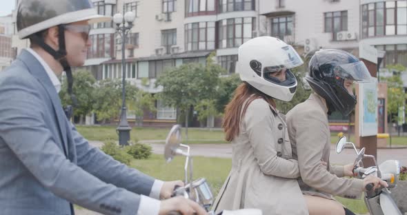 Side View of Bikers Riding Away in Slowmo. Portrait of Confident Caucasian Men and Woman Leaving on