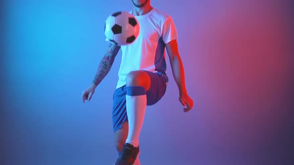 Football in Professional Uniform Juggling Ball in Studio Red and Blue Lights Slow Motion