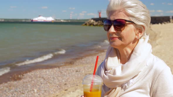 Senior Woman Drinking Shake on Summer Beach