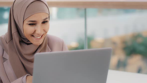 Happy Arab Woman Looking at Laptop Screen Checking Email Smiling Reading Good News Rejoicing in