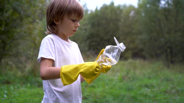 a Little Boy Volunteer Cleans Up Garbage in Nature
