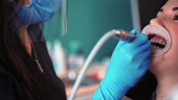 Woman Dentist with Assistant Does Brushing Teeth Female Patient in Dental Clinic