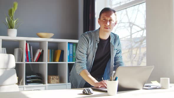 Young male entrepreneur works at home office at the computer.