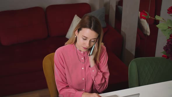 Pretty Young Woman Working on Laptop at Home Talking Phone and Had Bad News