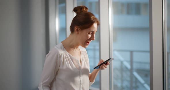 Excited Businesswoman Receiving Email with Good News on Smartphone