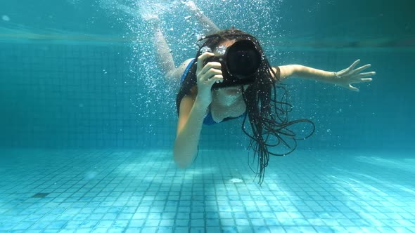 Travelling Girl in Asia. Happy Young Woman with Beautiful Long Hair Swim Under Water with Camera in