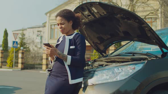 Woman Near Broken Car Browsing Phone for Road Help