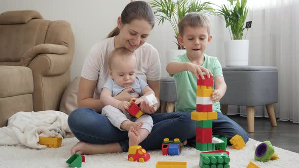 Smiling Happy Family Building High Tower with Toy Blocks and Bricks