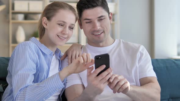 Young Couple Using Smartphone Messaging