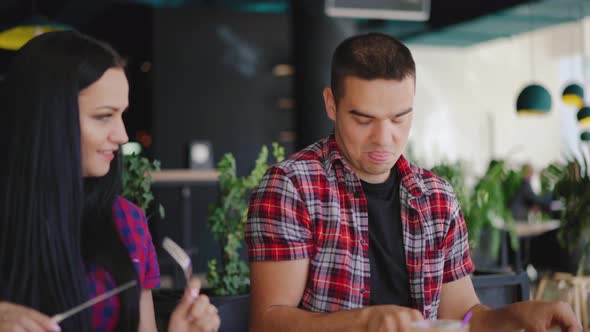 Funny Man and Woman are Playing with Cutlery in Their Hands 