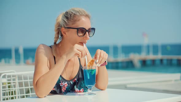 Happy Woman Drinking Coctails On Resort Beach Bar Counter.Woman Drinking Cocktail And Looking On Sea