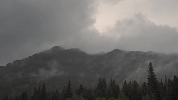 Time lapse of dark storm clouds rolling through mountains