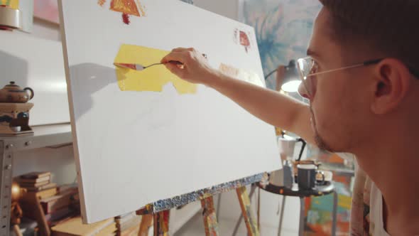 Artist Applying Paint to Canvas with Palette Knife